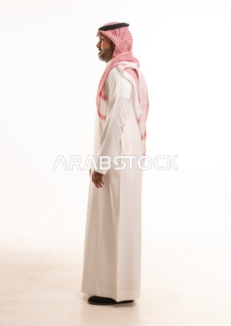 تعابير وجه ابتسامة يدين على الجانب، الاهتمام بالمظهر الخارجي والأناقة، تعابير السرور والسعادة، بورتريه  جانبي لرجل عربي خليجي سعودي يرتدي الثوب التقليدي، شاب سعودي ،مفهوم التعبير بالإشارة، صورة الجسم بالطول الكامل، خلفية بيضاء