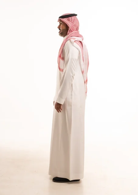 Facial expressions of a smile with hands on the side, attention to appearance and elegance, expressions of joy and happiness, a side portrait of a Saudi Arabian Gulf man wearing traditional attire, a young Saudi man, the concept of expression through gesture, full-body image, white background.