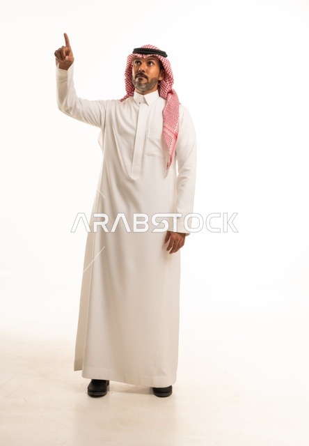 The gesture pointing to something above, facial expressions and hand raised, concern for external appearance and elegance, expressions of guessing and expectation, a side portrait of a young Saudi Arabian Gulf man wearing traditional attire, the concept of expression through gesture, full-body image, white background.