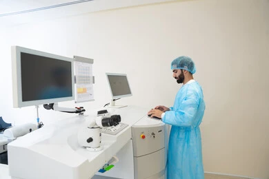 استخدام التكنولوجيا المتطورة في التشخيص والعلاج البصري، الاستفادة من التصوير الشعاعي والتقنيات الحديثة في مجال طب العيون،طبيب عربي خليجي سعودي يرتدي الزي الرسمي المعقم يتابع صور الأشعة العينية على جهاز الحاسوب داخل المركز الطبي للعيون، فحص دقيق لحالة الشبكية والقرنية، العناية بصحة العين وتحسين الرؤية، خلفية داخلية للمركز الطبي