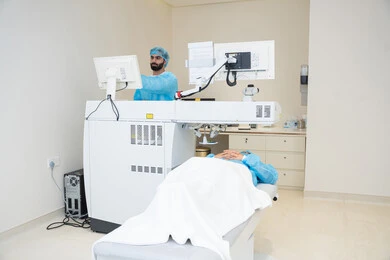 Utilizing radiographic imaging and modern techniques in the field of ophthalmology, employing advanced technology in visual diagnosis and treatment, an Arab Gulf Saudi doctor wearing sterile official attire is reviewing eye radiography images on a computer inside the eye medical center, a thorough examination of the retina and cornea, caring for eye health and improving vision, an interior background of the medical center.