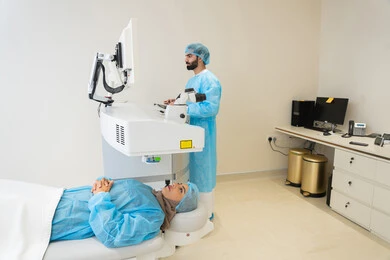 استخدام التكنولوجيا المتطورة في التشخيص والعلاج البصري، الاستفادة من التصوير الشعاعي والتقنيات الحديثة في مجال طب العيون،طبيب عربي خليجي سعودي يرتدي الزي الرسمي المعقم يتابع صور الأشعة العينية على جهاز الحاسوب داخل المركز الطبي للعيون، فحص دقيق لحالة الشبكية والقرنية، العناية بصحة العين وتحسين الرؤية، خلفية داخلية للمركز الطبي