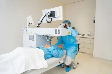 Laser vision correction procedure, eliminating problems of poor vision and nearsightedness, restoring clear vision without the need for prescription glasses, healthy eyes and more accurate vision, a veiled Arab Gulf Saudi woman wearing sterile official attire, a Saudi doctor preparing to perform LASIK surgery inside medical centers, focusing on eye care and improving vision.