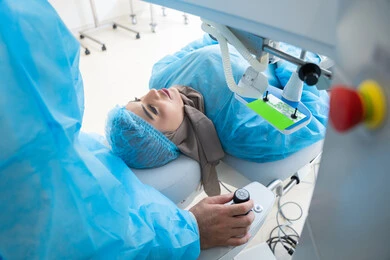 Laser vision correction procedure, eliminating problems of poor vision and nearsightedness, restoring clear vision without the need for prescription glasses, healthy eyes and more accurate vision, a veiled Arab Gulf Saudi woman wearing sterile official attire, a Saudi doctor preparing to perform LASIK surgery inside medical centers, focusing on eye care and improving vision.