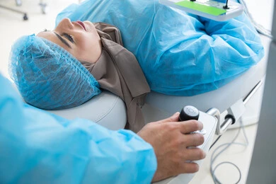 عملية تصحيح الإبصار بالليزر، القضاء على مشاكل ضعف النظر وقصر النظر، استعادة وضوح الرؤية بدون الحاجة للنظارات الطبية، عيون صحية ورؤية أكثر دقة، امرأة عربية خليجية سعودية محجبة ترتدي الزي الرسمي المعقم ، طبيب سعودي يستعد لإجراء عملية الليزك داخل المراكز الطبية، الاهتمام بالعناية بالعين وتحسين البصر