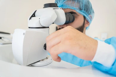 استخدام الأجهزة الحديثة المتطورة، تشخيص وتحديد المشاكل البصرية، رجل عربي خليجي سعودي يرتدي الزي المعقم يقوم بفحص العين بجهاز المنظار العيني، تقييم مدى الرؤية والكشف عن الامراض العينية، مفهوم الخدمات والرعاية الصحية في المشافي والمراكز الطبية ، التأكد من صحة البصر