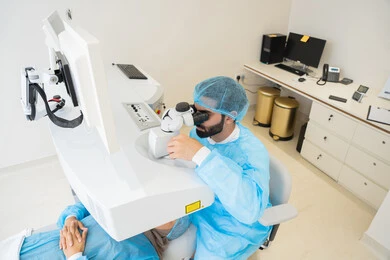 التأكد من صحة البصر، استخدام الأجهزة الحديثة المتطورة، تشخيص وتحديد المشاكل البصرية، رجل عربي خليجي سعودي يرتدي الزي المعقم يقوم بفحص العين بجهاز المنظار العيني، تقييم مدى الرؤية والكشف عن الامراض العينية، مفهوم الخدمات والرعاية الصحية في المشافي والمراكز الطبية