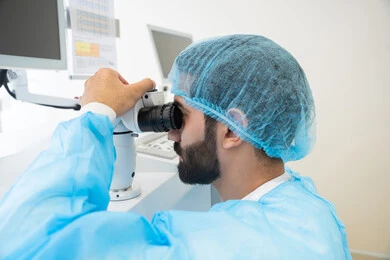 The use of advanced modern devices, diagnosing and identifying visual problems, an Arab Gulf Saudi man wearing sterile attire examining the eye with an ophthalmoscope, assessing the extent of vision and detecting eye diseases, the concept of services and healthcare in hospitals and medical centers, ensuring the accuracy of vision.