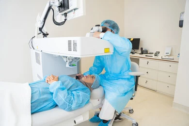Laser vision correction procedure, eliminating problems of poor vision and nearsightedness, restoring clear vision without the need for prescription glasses, healthy eyes and more accurate vision, a veiled Arab Gulf Saudi woman wearing sterile official attire, a Saudi doctor preparing to perform LASIK surgery inside medical centers, focusing on eye care and improving vision.