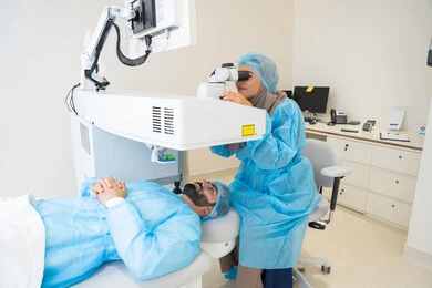 استعادة وضوح الرؤية بدون الحاجة للنظارات الطبية، عيون صحية ورؤية أكثر دقة، رجل عربي خليجي سعودي  يرتدي الزي الرسمي المعقم ، طبيبه سعوديه تكشف لإجراء عملية الليزك داخل المراكز الطبية، عملية تصحيح الإبصار بالليزر، القضاء على مشاكل ضعف النظر وقصر النظر،الاهتمام بالعناية بالعين وتحسين البصر