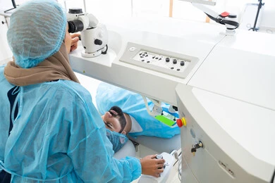 Eliminating problems of poor vision and nearsightedness, restoring clear vision without the need for prescription glasses, healthy eyes and more accurate vision, an Arab Gulf Saudi man wearing sterile official attire, a Saudi doctor revealing to perform LASIK surgery inside medical centers, laser vision correction surgery, focusing on eye care and improving vision.