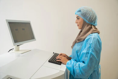 استخدام التكنولوجيا المتطورة في التشخيص والعلاج البصري، الاستفادة من التصوير الشعاعي والتقنيات الحديثة في مجال طب العيون،طبيبة عربية خليجية سعودية ترتدي الزي الرسمي المعقم تتابع صور الأشعة العينية على جهاز الحاسوب داخل المركز الطبي للعيون، فحص دقيق لحالة الشبكية والقرنية، العناية بصحة العين وتحسين الرؤية، خلفية داخلية للمركز الطبي