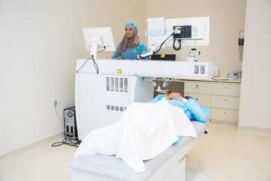 A thorough examination of the retina and cornea, utilizing radiographic imaging and modern techniques in the field of ophthalmology, employing advanced technology in visual diagnosis and treatment, an Arab Gulf Saudi female doctor wearing sterile official attire monitors eye radiology images on a computer inside the eye medical center, caring for eye health and improving vision, an interior background of the medical center.