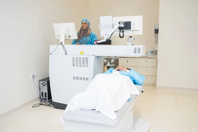 Caring for eye health and improving vision, benefiting from radiographic imaging and modern techniques in the field of ophthalmology, using advanced technology in optical diagnosis and treatment, an Arab Gulf Saudi female doctor wearing sterile official attire is reviewing eye radiology images on a computer inside the eye medical center, a thorough examination of the condition of the retina and cornea, an internal background of the medical center.