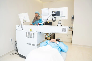The use of advanced technology in visual diagnosis and treatment, benefiting from radiographic imaging and modern techniques in the field of ophthalmology, an Arab Gulf Saudi female doctor wearing sterile official attire monitors eye radiology images on a computer inside the eye medical center, a thorough examination of the retina and cornea, caring for eye health and improving vision, an interior background of the medical center.