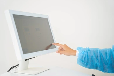 An Arab Gulf Saudi female doctor wearing sterile official attire is monitoring eye radiography images on a computer inside the eye medical center, benefiting from radiographic imaging and modern technologies in the field of ophthalmology, using advanced technology in visual diagnosis and treatment, conducting a thorough examination of the retina and cornea, caring for eye health and improving vision, with an interior background of the medical center.