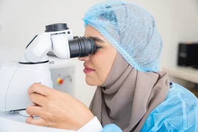 Diagnosis and identification of visual problems, an Arab Gulf Emirati female doctor examines the eye using an ophthalmoscope, assesses the level of vision and detects eye diseases, the concept of services and healthcare in hospitals and medical centers, the use of modern advanced devices, a Saudi woman ensures the health of her eyesight.