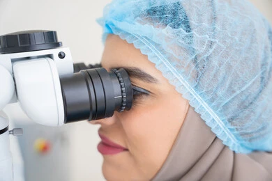 The concept of healthcare services and medical care in hospitals and medical centers, the use of advanced modern devices, diagnosing and identifying visual problems, an Arab Gulf Emirati female doctor examining the eye with an ophthalmoscope, assessing the level of vision and detecting eye diseases, a Saudi woman ensuring the health of her eyesight.