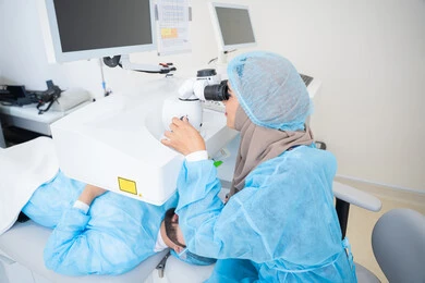 عيون صحية ورؤية أكثر دقة، رجل عربي خليجي سعودي  يرتدي الزي الرسمي المعقم ، طبيبه سعوديه تكشف لإجراء عملية الليزك داخل المراكز الطبية، عملية تصحيح الإبصار بالليزر، القضاء على مشاكل ضعف النظر وقصر النظر، استعادة وضوح الرؤية بدون الحاجة للنظارات الطبية،الاهتمام بالعناية بالعين وتحسين البصر