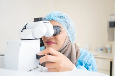 The use of advanced modern devices, diagnosing and identifying visual problems, an Arab Gulf Emirati doctor examining the eye with an ophthalmoscope, assessing the level of vision and detecting eye diseases, the concept of health services and care in hospitals and medical centers, a Saudi woman ensuring the health of vision.