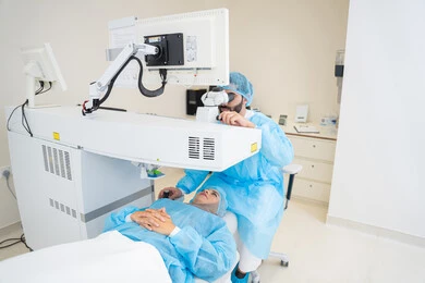 Laser vision correction procedure, eliminating problems of poor vision and nearsightedness, restoring clear vision without the need for glasses, healthy eyes and more accurate vision, a Saudi Arabian Gulf woman wearing a hijab in sterile official attire, a Saudi doctor preparing to perform LASIK surgery inside medical centers, focusing on eye care and improving vision.