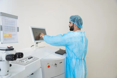 The use of advanced technology in visual diagnosis and treatment, benefiting from radiographic imaging and modern techniques in the field of ophthalmology, an Arab Gulf Saudi doctor wearing sterile official attire is monitoring eye radiology images on a computer inside the eye medical center, a thorough examination of the condition of the retina and cornea, caring for eye health and improving vision, an interior background of the medical center.