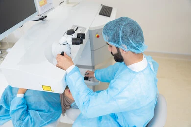 A Saudi Arabian Gulf woman wearing a hijab and dressed in sterile official attire, a Saudi doctor preparing to perform LASIK surgery inside medical centers, a laser vision correction procedure, eliminating problems of poor vision and nearsightedness, restoring clear vision without the need for glasses, healthy eyes and more precise vision, focusing on eye care and improving eyesight.