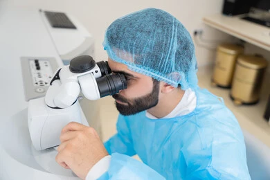 The use of advanced modern devices, diagnosing and identifying visual problems, an Arab Gulf Saudi man wearing sterile attire examining the eye with an ophthalmoscope, assessing the extent of vision and detecting eye diseases, the concept of services and healthcare in hospitals and medical centers, ensuring the accuracy of vision.