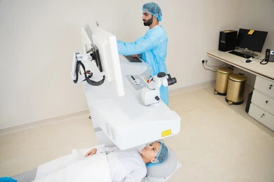 تعابير التركيز والاندماج، الاستفادة من التصوير الشعاعي والتقنيات الحديثة في مجال طب العيون، استخدام التكنولوجيا المتطورة في التشخيص والعلاج البصري، طبيب عربي خليجي سعودي يرتدي الزي الرسمي المعقم يتابع صور الأشعة العينية على جهاز الحاسوب داخل المركز الطبي للعيون، فحص دقيق لحالة الشبكية والقرنية، العناية بصحة العين وتحسين الرؤية، خلفية داخلية للمركز الطبي