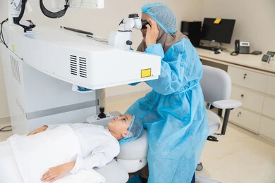 A Saudi Arabian Gulf Arab boy wearing sterile official attire, a Saudi female doctor reveals to perform LASIK surgery inside medical centers, focusing on eye care and vision improvement, laser vision correction surgery, eliminating problems of poor vision and nearsightedness, restoring clear vision without the need for glasses, healthy eyes, and more accurate vision.