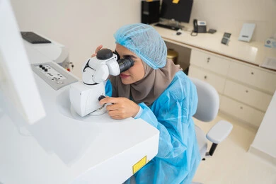 The concept of healthcare services in hospitals and medical centers, the use of advanced modern devices, diagnosing and identifying visual problems, an Arab Gulf Emirati doctor examining the eye with an ophthalmoscope, assessing the level of vision and detecting eye diseases, a Saudi woman ensuring the health of her eyesight.