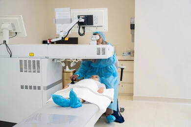 A Saudi Arabian Gulf Arab boy wearing sterile official attire, a Saudi female doctor reveals to perform LASIK surgery inside medical centers, focusing on eye care and vision improvement, laser vision correction surgery, eliminating problems of poor vision and nearsightedness, restoring clear vision without the need for glasses, healthy eyes, and more accurate vision.