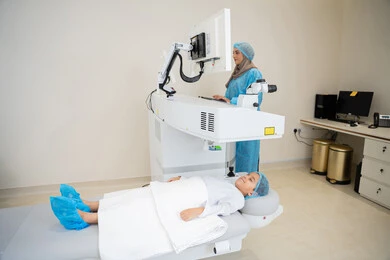 الاستفادة من التصوير الشعاعي والتقنيات الحديثة في مجال طب العيون، استخدام التكنولوجيا المتطورة في التشخيص والعلاج البصري، طبيبة عربية خليجية سعودية ترتدي الزي الرسمي المعقم تتابع صور الأشعة العينية على جهاز الحاسوب داخل المركز الطبي للعيون، فحص دقيق لحالة الشبكية والقرنية، العناية بصحة العين وتحسين الرؤية، خلفية داخلية للمركز الطبي