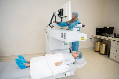 فحص دقيق لحالة الشبكية والقرنية، الاستفادة من التصوير الشعاعي والتقنيات الحديثة في مجال طب العيون، استخدام التكنولوجيا المتطورة في التشخيص والعلاج البصري، طبيبة عربية خليجية سعودية ترتدي الزي الرسمي المعقم تتابع صور الأشعة العينية على جهاز الحاسوب داخل المركز الطبي للعيون، العناية بصحة العين وتحسين الرؤية، خلفية داخلية للمركز الطبي