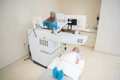 The use of advanced technology in visual diagnosis and treatment, benefiting from radiographic imaging and modern techniques in the field of ophthalmology, an Arab Gulf Saudi female doctor wearing sterile official attire monitors eye radiology images on a computer inside the eye medical center, a thorough examination of the retina and cornea, caring for eye health and improving vision, an interior background of the medical center.