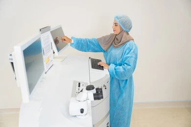Caring for eye health and improving vision, benefiting from radiography and modern techniques in the field of ophthalmology, using advanced technology in optical diagnosis and treatment, an Arab Gulf Saudi female doctor wearing sterile official attire is monitoring eye radiology images on a computer inside the eye medical center, a thorough examination of the condition of the retina and cornea, an internal background of the medical center.