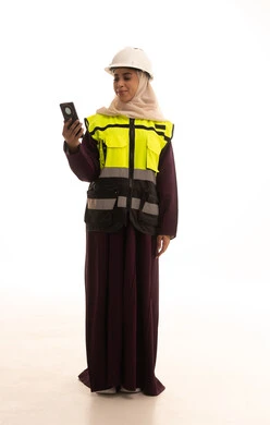 The use of modern technologies and techniques in the engineering sector, construction by the hands of the nation's sons, the concept of engineering and architectural constructions, a portrait of a Saudi Gulf Arab engineer wearing a helmet and safety vest browsing a mobile phone, full-body, white background.
