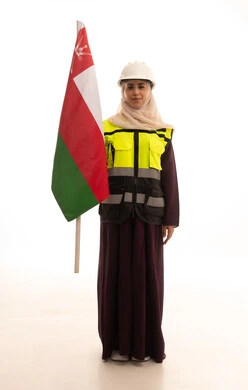 Pride in the symbols and the Omani flag, a sense of belonging to the country, celebrating the anniversary of the National Day, a portrait of a Saudi Gulf Arab engineer wearing a helmet and protective vest standing upright holding the flag of the Sultanate of Oman with expressions of self-confidence, full-body, white background.
