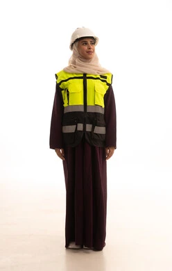 Looking at something, women's jobs and professions, the concept of engineering project management, standing with gestures of confidence, a portrait of a Saudi Gulf Arab engineer wearing a helmet and safety vest standing upright, full-body image, white background.