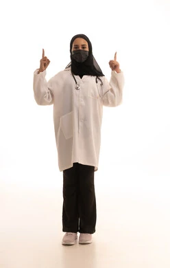 ايماءات الرقم واحد ,الالتزام بالاحترازات الوقائيه ضد كوفيد 19,بورتريه لطبيبة عربية خليجية سعودية ترتدي المعطف الطبي الأبيض وكمامة الوقاية ترفع إصبع السبابة للاعلى، الاشارة الى مكان ما، الجسم بالطول الكامل، خلفية بيضاء