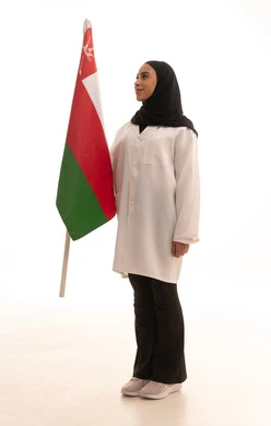 العمل في المجال الطبي، اليوم الوطني العماني 18 نوفمبر، إحياء ذكرى استقال الدولة 1650م، رفع علم سلطنة عمان, بورتريه لطبيبة عربية خليجية عمانية ترتدي المعطف الطبي  تقف باستقامة تنظر بايماءات الفخر، صورة لكامل الجسم، خلفية بيضاء