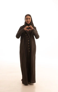 مفهوم المحبة والمودة، اظهار مشاعر الحب والشغف، ايماءات يدين على شكل قلب، بورتريه لامرأه عربيه خليجيه سعودية محجبة ترتدي العباءة تنظر إلى الكاميرا بتعابير السرور والسعادة، الجسم بالطول الكامل، خلفية بيضاء