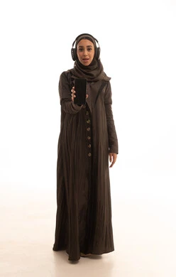 الاستغراب والانبهار والحماس، عرض شاشة سوداء فارغة عبر الجوال، استخدام جهاز تقني حديث ومتطور، بورتريه لامرأة عربية خليجية سعودية محجبة تضع الهيدفون تحمل بيدها الهاتف المحمول، النظر الى الكاميرا بايماءات الذهول والدهشة، الجسم بالطول الكامل، خلفية بيضاء