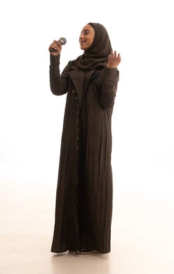 أداء العروض المسرحية، مواهب فنية في عالم الموسيقى، الفن المسرحي الغنائي، ممارسة هواية الغناء للتسلية والترفيه، بورترية لامراه عربيه خليجيه سعودية ترتدي العباءة و الحجاب تحمل بيديها الميكروفون، طول الجسم بالكامل، خلفية بيضاء