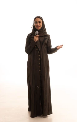 الفن المسرحي الغنائي، ممارسة هواية الغناء للتسلية والترفيه، مواهب فنية في عالم الموسيقى، تقديم العروضات المسرحية، بورترية لامراه عربيه خليجيه سعودية ترتدي العباءة و الحجاب تحمل بيديها الميكروفون، طول الجسم بالكامل، خلفية بيضاء