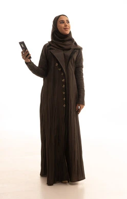 ايماءات السعادة و السرور، النظر الى شيء ما، الدردشة مع الأهل والأصدقاء وتصفح مواقع التواصل الاجتماعي، استخدام الأجهزة التقنية الحديثة، بورترية لامراه عربيه خليجيه سعودية ترتدي العباءة و الحجاب تمسك الهاتف المحمول، الجسم بالطول الكامل، خلفية بيضاء