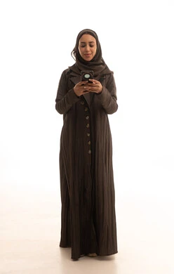 استخدام الأجهزة التقنية الحديثة، بورترية لامراه عربيه خليجيه سعودية ترتدي العباءة و الحجاب تمسك الهاتف المحمول، الدردشة مع الأهل والأصدقاء وتصفح مواقع التواصل الاجتماعي، ايماءات السعادة و السرور، الجسم بالطول الكامل، خلفية بيضاء