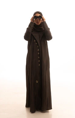 Thinking and looking towards the future, future planning for goals and ambitions, seeing distant things, love for exploration and adventure, a portrait of a young Arab Gulf Saudi woman wearing an abaya and hijab holding binoculars looking at something, full-body, white background.