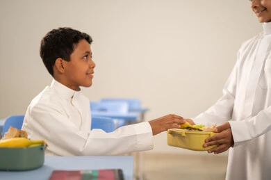 Gestures of affection and intimacy, expressions of happiness and joy, enjoying healthy food during school break, a group of Arab Gulf Saudi students sitting in their seats with lunch boxes in front of them, meals rich in essential nutrients for building the body. Gestures of affection and intimacy, expressions of happiness and joy, enjoying healthy food during school break, a group of Arab Gulf Saudi students sitting in their seats with lunch boxes in front of them, meals rich in essential nutrients for building the body.