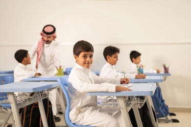 حوارات ودية بين الاستاذ والطلاب، جودة التعليم في السعودية، معلم عربي خليجي سعودي يرتدي الثوب التقليدي والشماغ يقوم بمناقشة الدروس مع طلابه، مجموعة من طلاب عربيين خليجيين سعوديين يرتدون الزي المدرسي يقومون بتأديه الواجبات ، المشاركة الفعالة للطلاب مع المدرسين، التربية والتعليم بالمناهج المقررة للتلاميذ